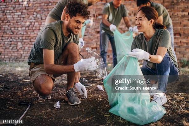 volunteers cleaning garbage after music festival/ concert - festival rubbish stock pictures, royalty-free photos & images