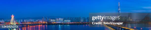 futuristic skyscraper cityscape illuminated at night across river panorama seoul - seoul skyline stock pictures, royalty-free photos & images