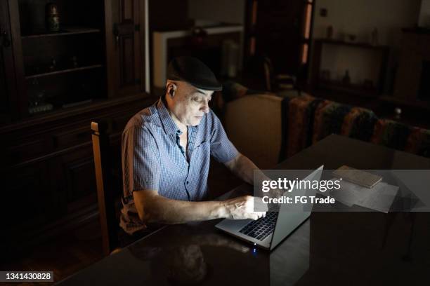 senior man working on the laptop at home - old man dark stock pictures, royalty-free photos & images