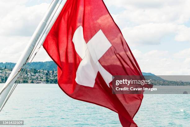 swiss flag on boat, zurich, switzerland - swiss flag stockfoto's en -beelden