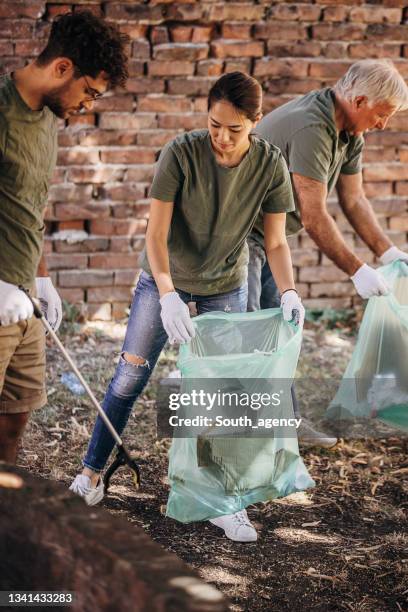 volunteers cleaning garbage after music festival/ concert - nature resources and conservation agency stock pictures, royalty-free photos & images