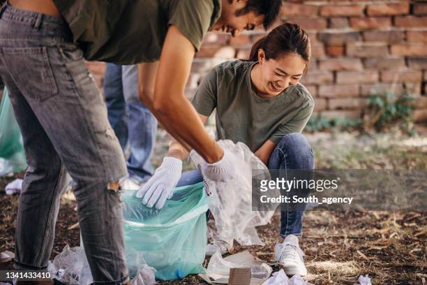 volunteers cleaning garbage after music festival/ concert - concert in aid of peace one day after party stockfoto's en -beelden