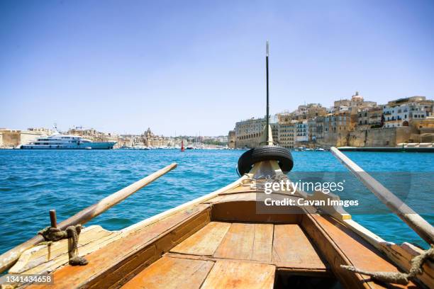traditional wooden water taxi crossing port from valletta to the three cities, malta - water taxi stock pictures, royalty-free photos & images