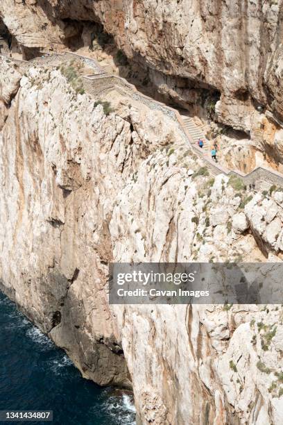 carved path on cliffs giving access to neptune's grotto (grotta di nettuno), capo caccia, sardinia, italy - neptune's grotto stock pictures, royalty-free photos & images