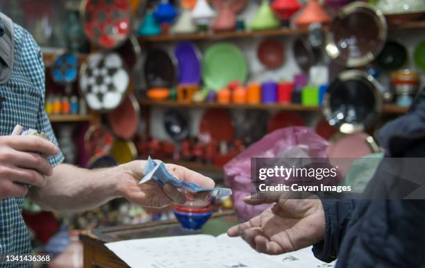 customer paying for goods in souk, marrakesh, morocco - zoco fotografías e imágenes de stock