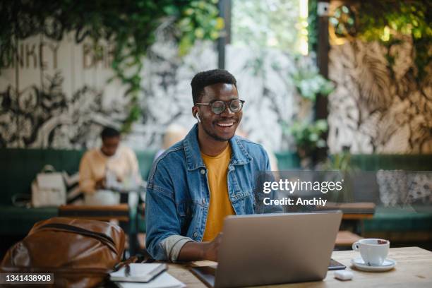 joven en una videollamada en un café - telecommuting fotografías e imágenes de stock