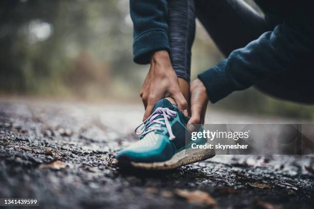 close up of unrecognizable athlete holding her ankle in pain at the park. - tornozelo imagens e fotografias de stock