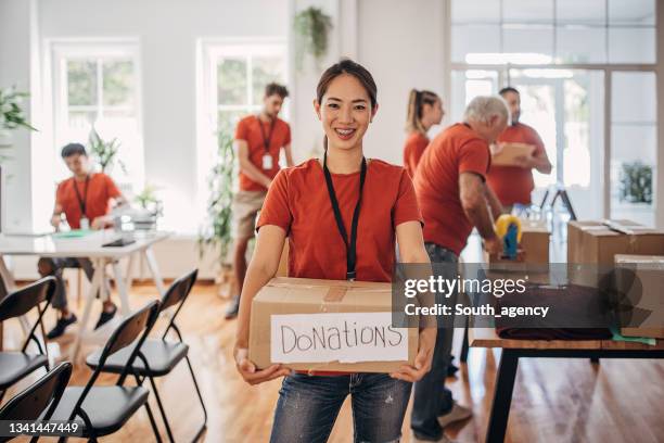 porträt eines freiwilligen mit einer spendenbox mit waren für menschen in not - charity stock-fotos und bilder