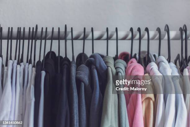 clothes on hangers on a wardrobe. - multi colored dress photos et images de collection