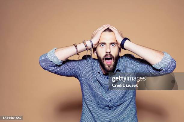 portrait of shoced bearded man - hands on head stock pictures, royalty-free photos & images