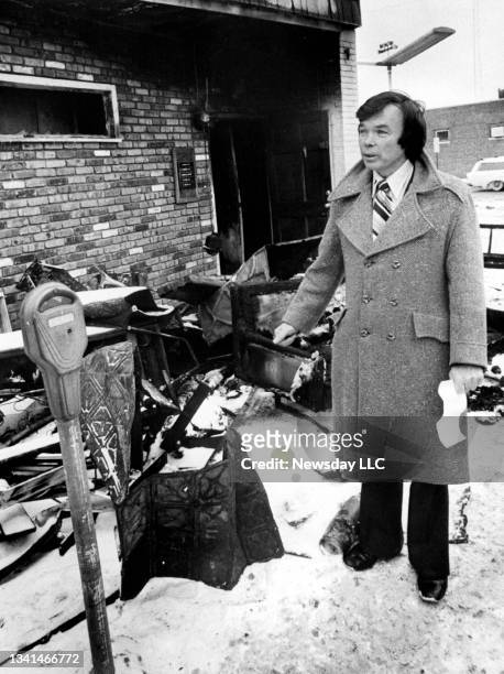 Birth control advocate Bill Baird stands in front of the fire-charred remains of his Hempstead, New York birth control clinic on February 16, 1979.