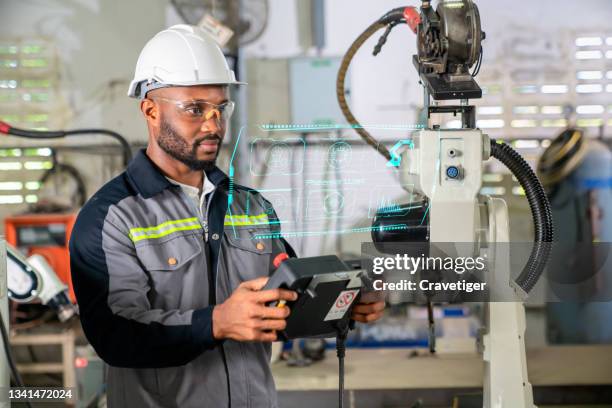 the robot trainer teaching the robotics arm  for welding metal process .modern factory for industrial manufacturing process with robot officer control. concepts factory 4.0 - modern industrial revolution stock pictures, royalty-free photos & images