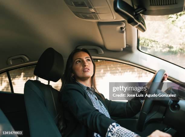 woman driving car and looking in rear view mirror"n - daylight saving time 2021 stock pictures, royalty-free photos & images