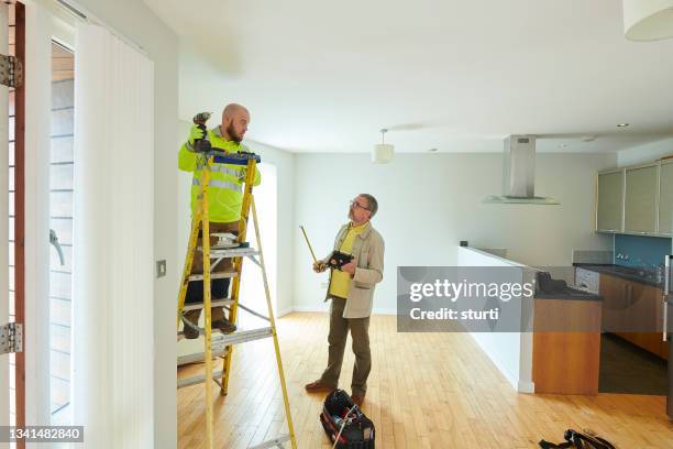 appaltatore e proprietario che effettua le riparazioni finali - casa in affitto foto e immagini stock