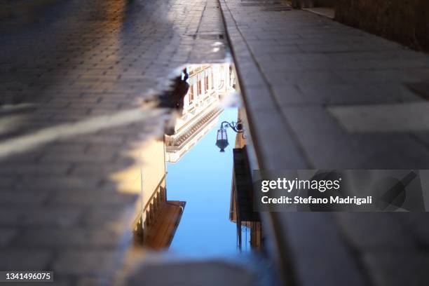 puddle reflection in city sidewalk architecture street - flaque photos et images de collection