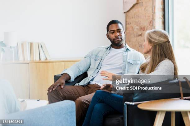 husband listens as wife shares during counseling session - couple discussion stock pictures, royalty-free photos & images