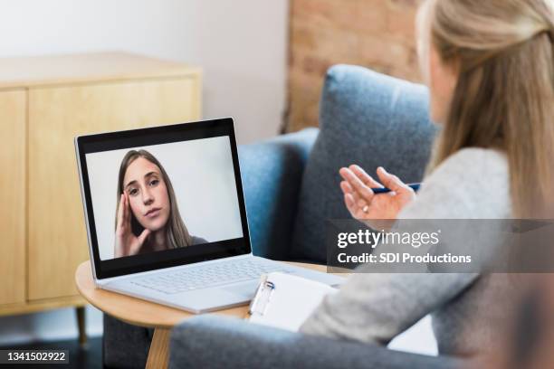 female therapist meets with patient via video conferencing - online therapy stock pictures, royalty-free photos & images