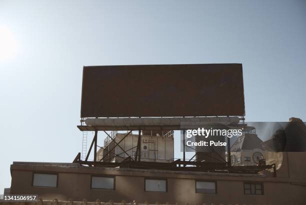 low angle view of billboard against clear blue sky and city landscape - us blank billboard stock pictures, royalty-free photos & images