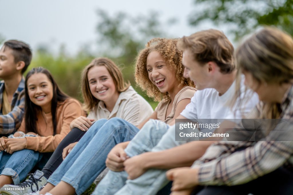 Multi-Ethnic High School Students Sitting Outside Laughing Together