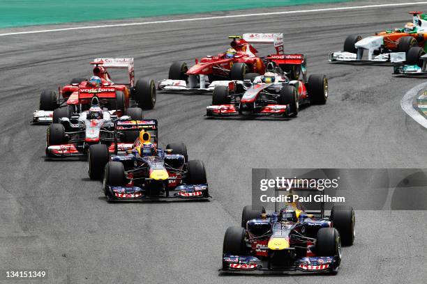 Sebastian Vettel of Germany and Red Bull Racing leads the field through the first corner at the start of the Brazilian Formula One Grand Prix at the...