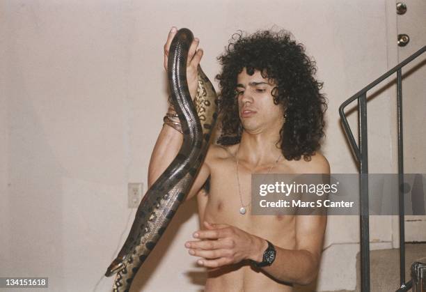 Guitarist Slash poses for a portrait with his pet snake, Clyde, in 1984 in Los Angeles, California.