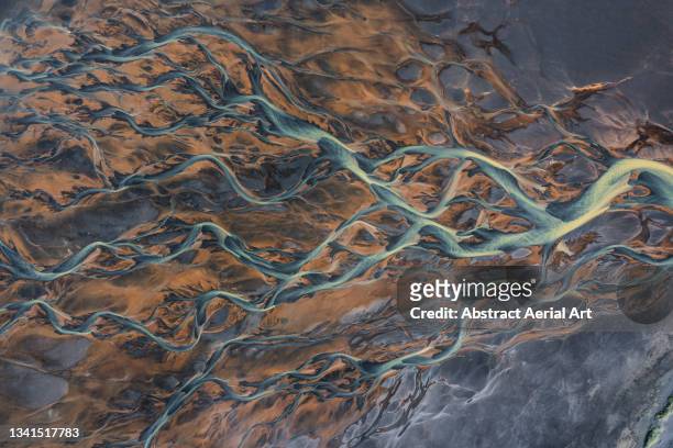 drone shot showing river channels flowing across a volcanic landscape, iceland - erosion foto e immagini stock