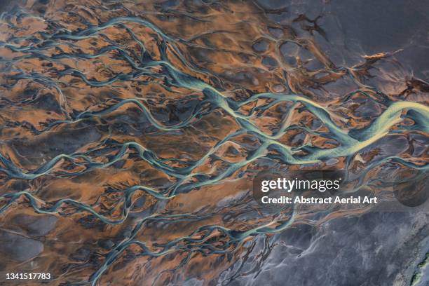 drone shot showing river channels flowing across a volcanic landscape, iceland - river stockfoto's en -beelden