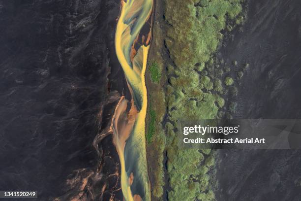 braided river flowing across a black sand beach photographed by drone, iceland - volcanic terrain ストックフォトと画像