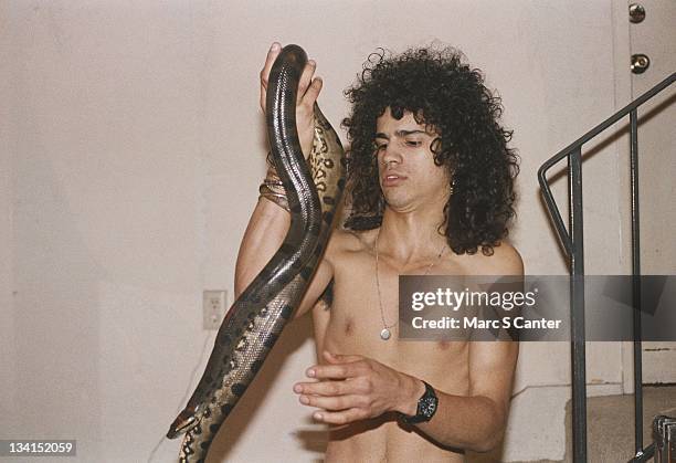 Guitarist Slash poses for a portrait with his pet snake, Clyde, in 1984 in Los Angeles, California.