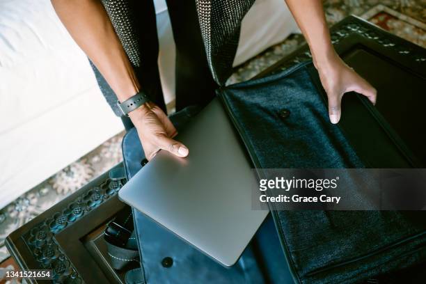 woman removes laptop from bag - laptop bag stock pictures, royalty-free photos & images