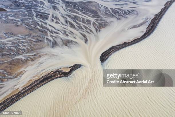 aerial point of view showing a braided river flowing between black sand beaches into glacial meltwater, iceland - central highlands iceland stock pictures, royalty-free photos & images