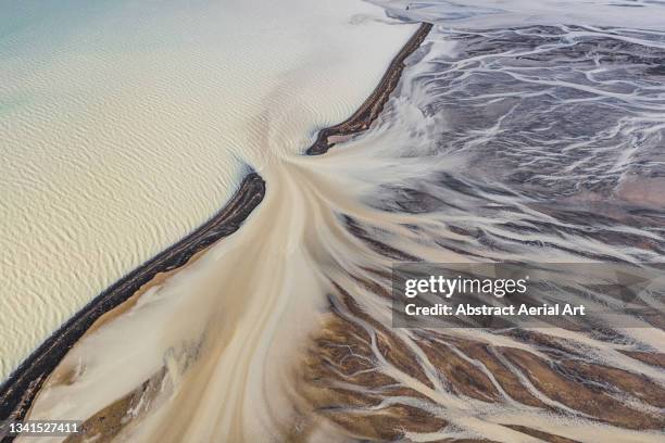 braided river flowing into glacial meltwater between black sand beaches seen from a high angle point of view, iceland - central highlands iceland stock pictures, royalty-free photos & images