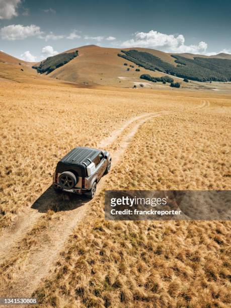 aerial view of the new land rover defender in the dry italian countryside - four wheel drive stock pictures, royalty-free photos & images