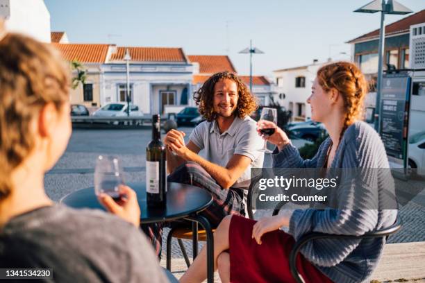 friends drinking wine in town square - faro city portugal stock-fotos und bilder