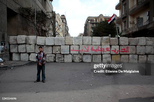 Protester stands next to a barricade mounted by the army to keep police from clashing with protestors in Mohammed Mahmoud near Tahrir Square on...