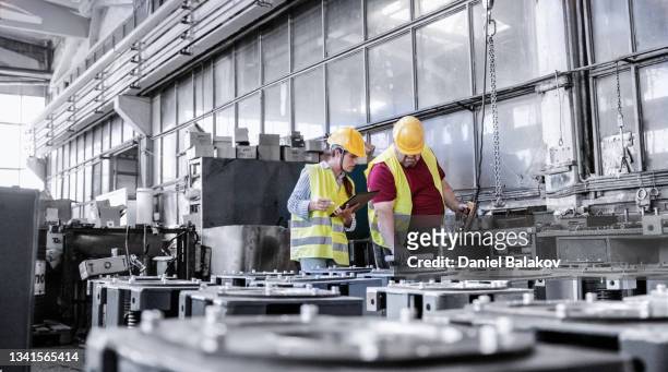 ingenieure, die in der metallindustrie arbeiten und die qualitätskontrolle der produktion mit tablet durchführen. - factory stock-fotos und bilder