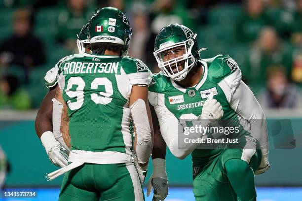 Anthony Lanier II celebrates with Pete Robertson of the Saskatchewan Roughriders after a big play in the game between the Toronto Argonauts and...