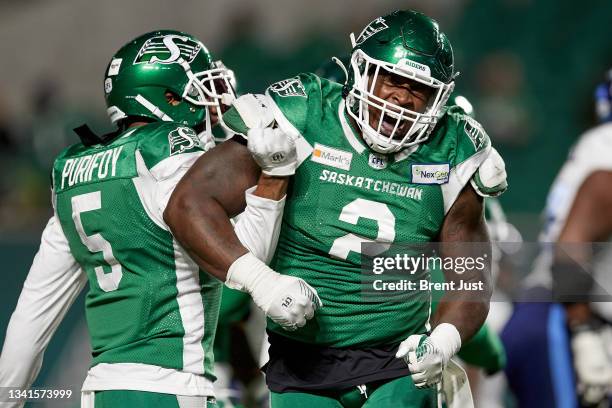 Micah Johnson celebrates with Loucheiz Purifoy of the Saskatchewan Roughriders after making a tackle in the game between the Toronto Argonauts and...