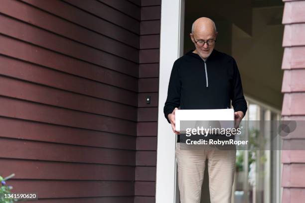 maschio anziano raccoglie un bidone più fresco di pesce congelato alla sua porta di casa - pacific cod foto e immagini stock
