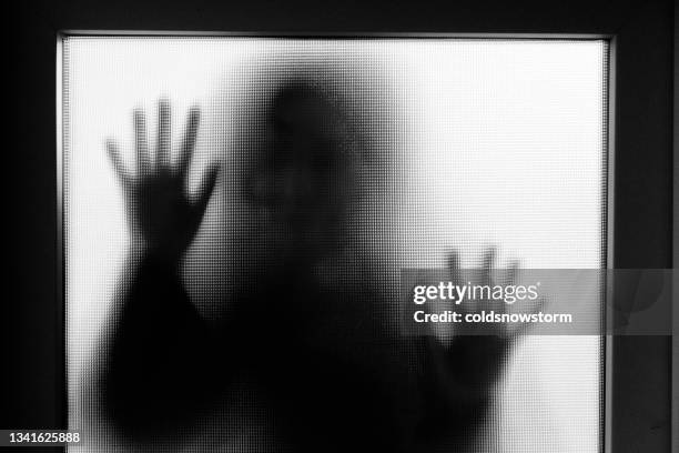 vittima di abusi domestici con le mani premute contro la finestra di vetro - violenza sessuale foto e immagini stock