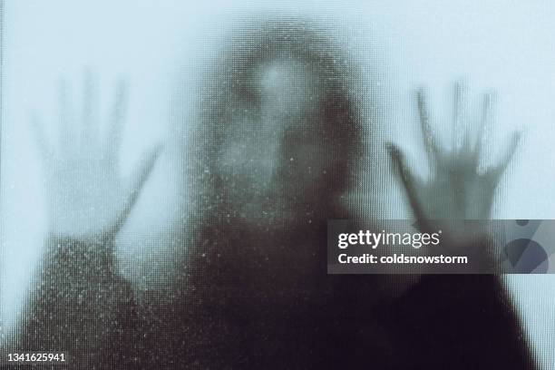 víctima de abuso doméstico con las manos presionadas contra la ventana de vidrio - ghost fotografías e imágenes de stock