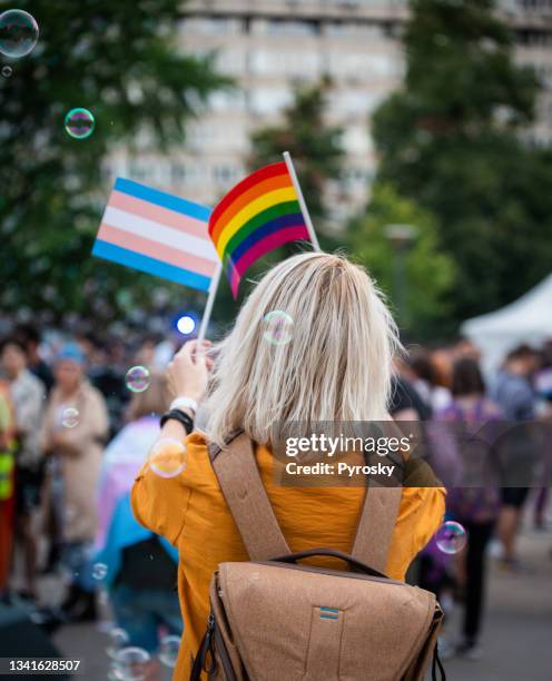 mujer ondeando banderas del orgullo arco iris en el love festival - lgbtqi rights fotografías e imágenes de stock