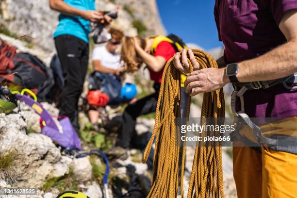 guía de montaña alpino que escala en vía ferrata con grupo de senderismo - escalada libre fotografías e imágenes de stock