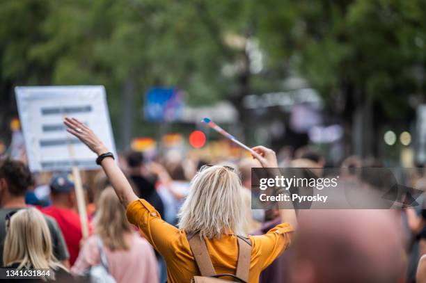 woman waving  rainbow pride flag at the love festival - march for humanity stock pictures, royalty-free photos & images