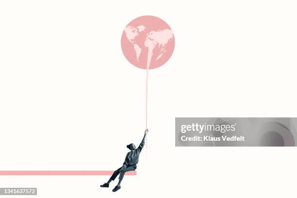 woman holding at large pink balloon with world map - transition collage stockfoto's en -beelden