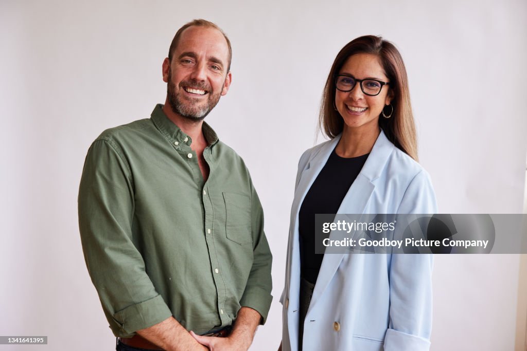 Zwei Geschäftsleute lächeln zusammen vor weißem Hintergrund