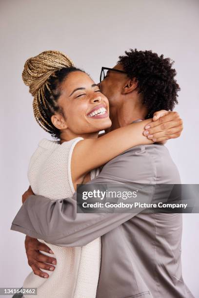 laughing young woman hugging her boyfriend against a white background - boyfriend stock pictures, royalty-free photos & images