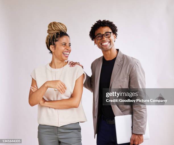 lachende junge geschäftsleute, die seite an seite stehen - nebeneinander-stehen stock-fotos und bilder