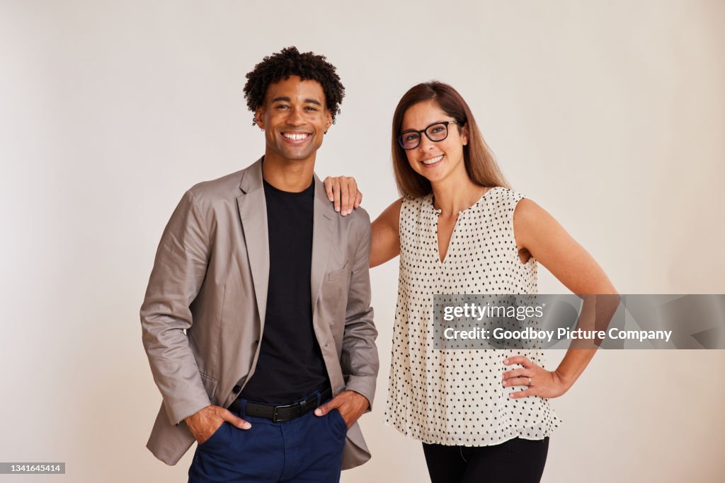 Diverse young businesspeople standing on a white background and smiling