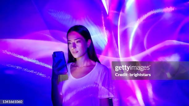 image projection on a woman using a smart phone - pink colour stockfoto's en -beelden